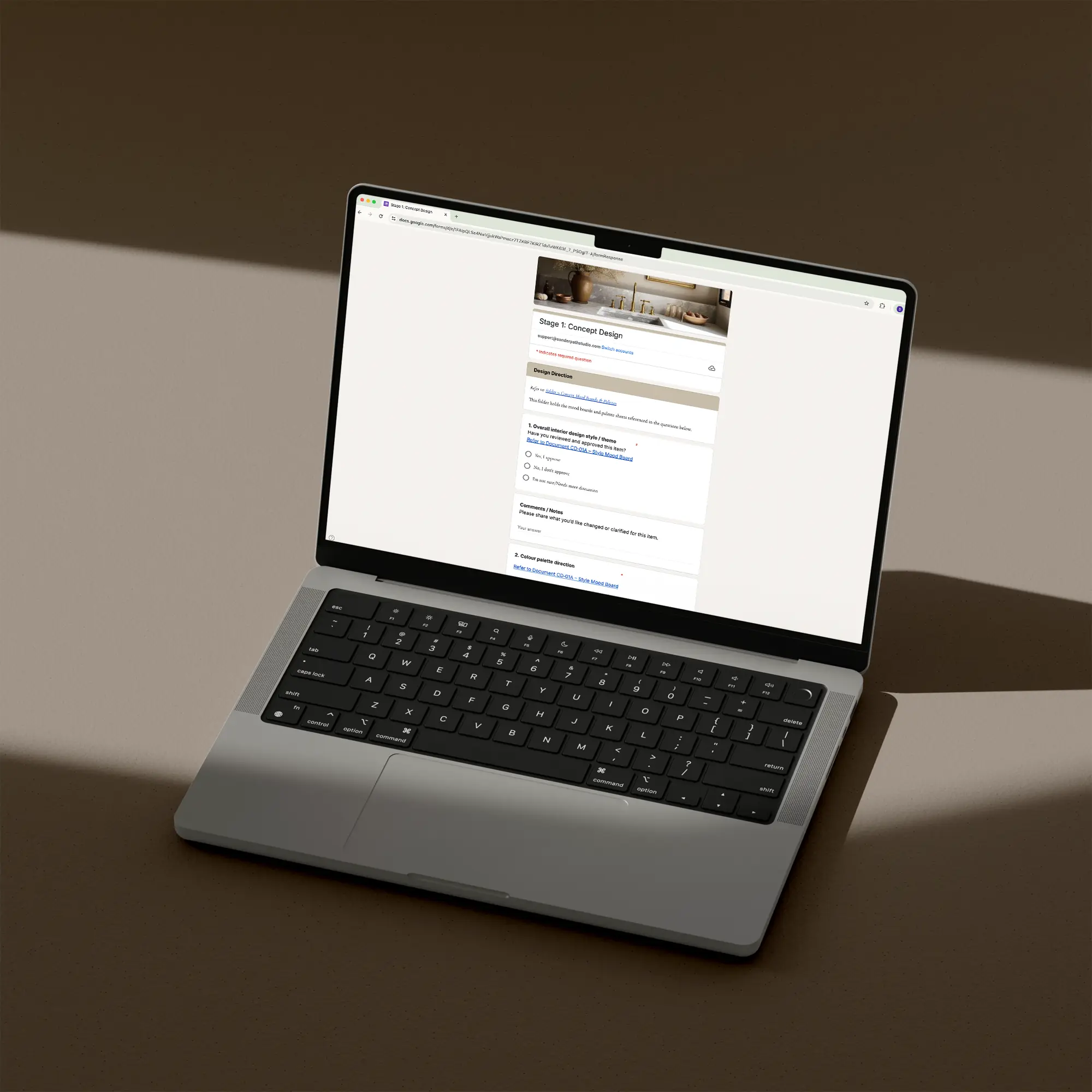 Laptop on a brown surface showing a page of the client feedback and sign-off checklist template for interior designers