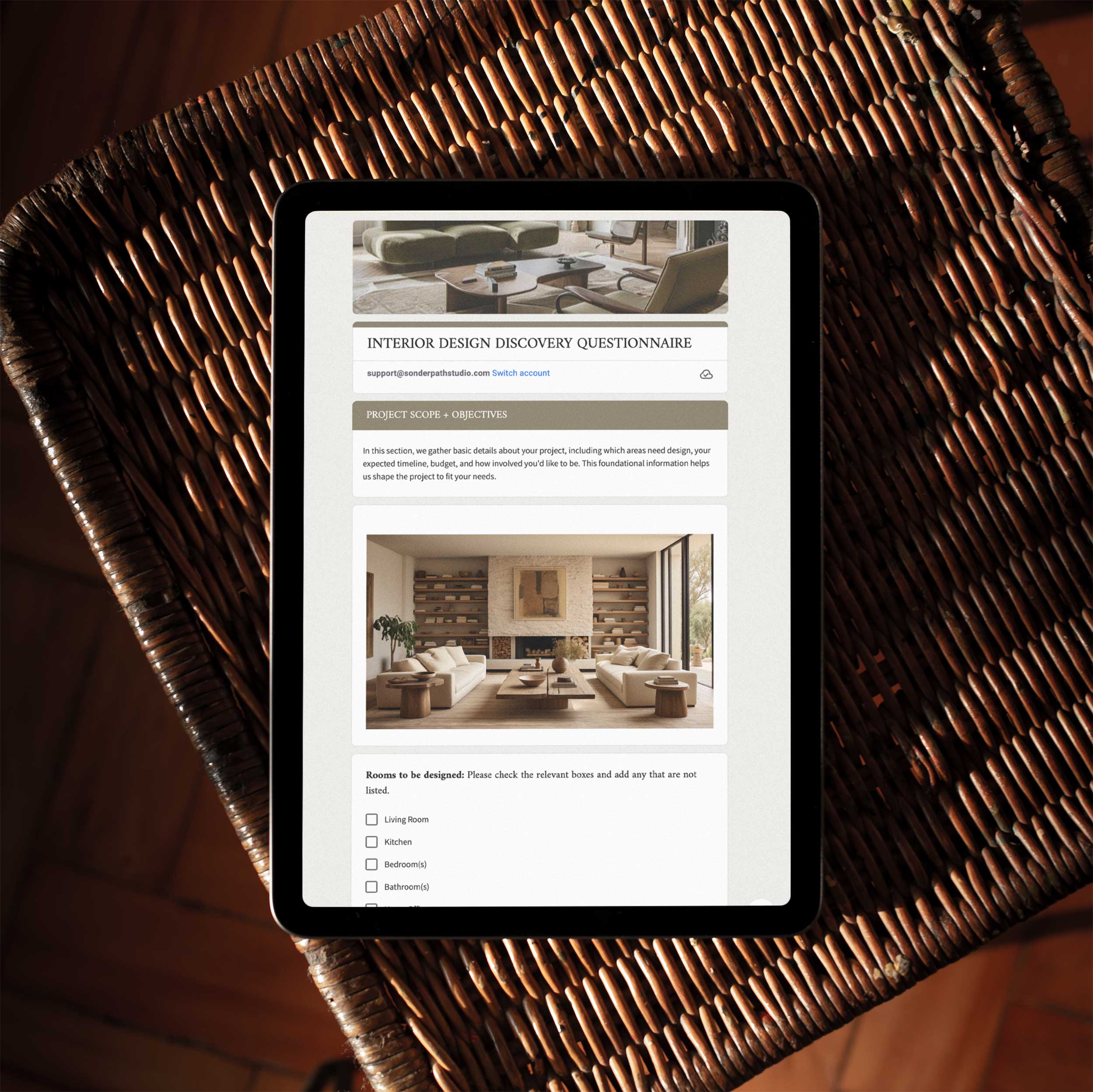 A digital version of an interior design discovery questionnaire displayed on a tablet, resting on a wicker table.
